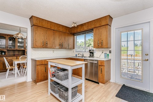 Kitchen featuring wood-finish cabinetry, light countertops, and wood-finish flooring - 18316 78 Avenue Nw, Edmonton, AB - Indoor Photo Showing Kitchen