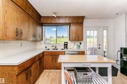 Kitchen featuring wood cabinetry, white countertops, dual basin sink, and a stainless steel dishwasher - 