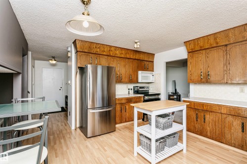 Kitchen featuring wood-finish cabinetry, light-toned countertops, and light wood-finish flooring - 18316 78 Avenue Nw, Edmonton, AB - Indoor Photo Showing Kitchen