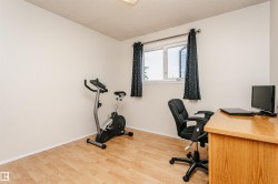 Bright room featuring wood-finish flooring, white walls, and a window with dark curtains - 