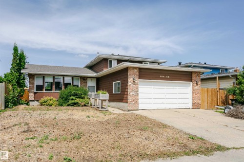 Split-level residence featuring a two-car garage with a white sectional door and an asphalt driveway - 18316 78 Avenue Nw, Edmonton, AB - Outdoor