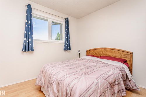 Bright bedroom featuring a large window, light wood-finish flooring, and a neutral wall color - 18316 78 Avenue Nw, Edmonton, AB - Indoor Photo Showing Bedroom