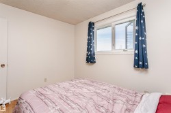 Bedroom with a single casement window and wood-finish flooring - 
