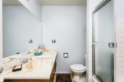 Bathroom featuring a full-width vanity mirror, integrated sink, and patterned countertop - 