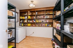 Room featuring extensive built-in wooden shelving, durable wood-finish flooring, and a ceiling-mounted light fixture - 