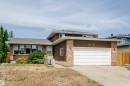 Brown siding home featuring a brick facade, white garage door, and a multi-paned bay window - 18316 78 Avenue Nw, Edmonton, AB  - Outdoor 