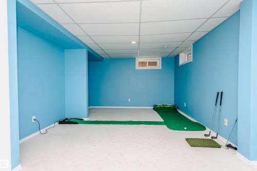 Finished basement space featuring light blue walls, white trim, and a suspended acoustic ceiling - 18316 78 Avenue Nw, Edmonton, AB - Indoor