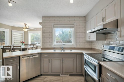 Kitchen with two-tone cabinetry, stainless steel appliances, and subway tile backsplash - 568 Buchanan Road Nw, Edmonton, AB - Indoor Photo Showing Kitchen With Double Sink