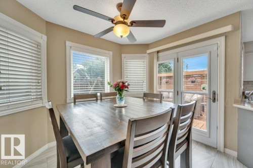 overlooking the back yard with a door opening onto the large deck. - 568 Buchanan Road Nw, Edmonton, AB - Indoor Photo Showing Dining Room