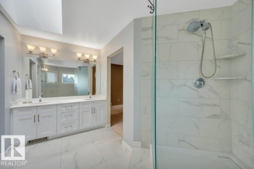 Spacious bathroom featuring a glass-enclosed shower with tiled walls and built-in corner shelves - 568 Buchanan Road Nw, Edmonton, AB - Indoor Photo Showing Bathroom