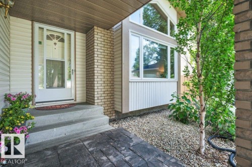Front entry featuring a storm door, concrete steps, and an embossed concrete walkway - 568 Buchanan Road Nw, Edmonton, AB - Outdoor With Exterior