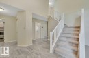 Foyer featuring light-toned tile flooring, a carpeted staircase with white railings. - 568 Buchanan Road Nw, Edmonton, AB  - Indoor Photo Showing Other Room 