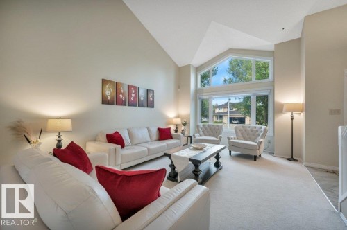 Spacious living area featuring a vaulted ceiling and expansive windows - 568 Buchanan Road Nw, Edmonton, AB - Indoor Photo Showing Living Room
