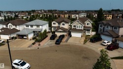 Two-story residence with a gray shingle roof, white exterior siding, and an attached two-car garage - 