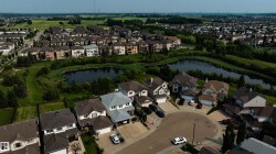 Residential community featuring a cul-de-sac with multiple properties, direct access to a naturalized pond, surrounding green spaces, and a variety of architectural styles - 