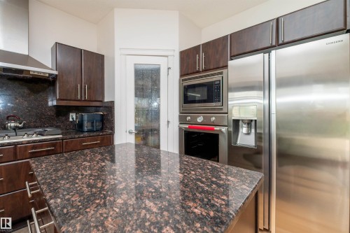 Kitchen featuring dark wood cabinetry and granite countertops - 715 Wildwood Point(E) Nw, Edmonton, AB - Indoor Photo Showing Kitchen With Upgraded Kitchen
