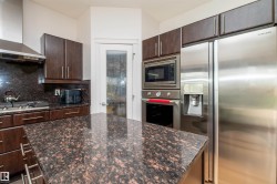 Kitchen featuring dark wood cabinetry and granite countertops - 