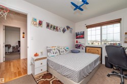 Carpeted bedroom with a large window featuring blinds - 