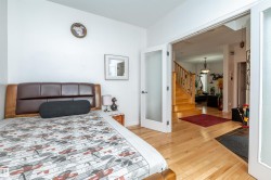 Light wood-finish flooring throughout, complemented by frosted glass French doors - 