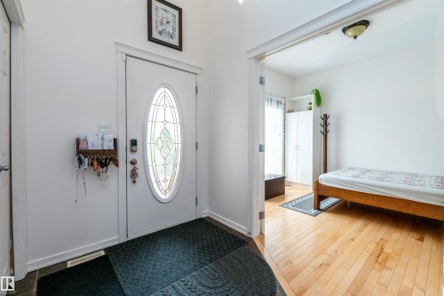 Entryway featuring a white door with an oval stained-glass insert, slate tile flooring, and light wood-finish flooring - 715 Wildwood Point(E) Nw, Edmonton, AB - Indoor Photo Showing Other Room