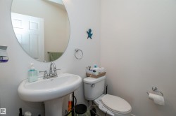 Pedestal sink with a chrome faucet, oval mirror, and white walls - 