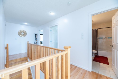Upper-level hallway featuring wood-finish flooring, recessed lighting, and a wood railing system - 715 Wildwood Point(E) Nw, Edmonton, AB - Indoor Photo Showing Other Room