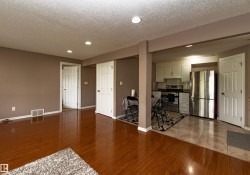 Open-concept living space featuring wood-finish flooring, recessed lighting, and a neutral wall color - 