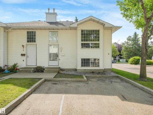 White siding exterior featuring multiple window styles and a prominent front-facing gable - #2 3311 58 St Nw, Edmonton, AB - Outdoor