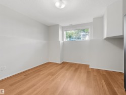 Room featuring wood-finish flooring, white baseboards, and light gray walls - 