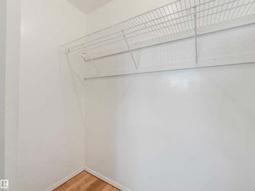 White wire shelving system with a hanging rod - #2 3311 58 St Nw, Edmonton, AB - Indoor With Storage