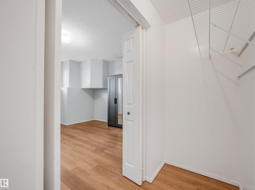 Interior space featuring wood-finish flooring, white walls, and a recessed ceiling light fixture - #2 3311 58 St Nw, Edmonton, AB - Indoor