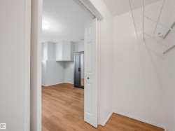 Interior space featuring wood-finish flooring, white walls, and a recessed ceiling light fixture - 