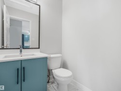 Powder room featuring a blue vanity with a white countertop, modern sink, and chrome faucet - 