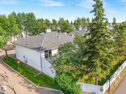 Exterior featuring white siding, a gray shingle roof, and a skylight - 