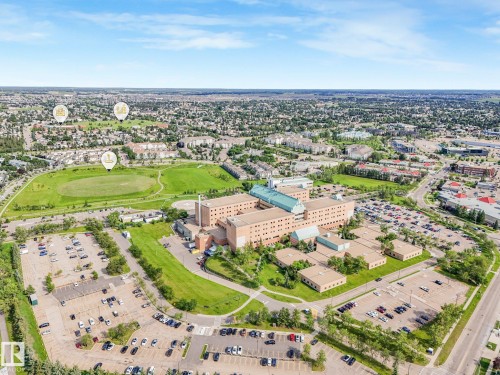 Aerial perspective showcasing a large-scale institutional building with extensive parking facilities - #2 3311 58 St Nw, Edmonton, AB - Outdoor With View