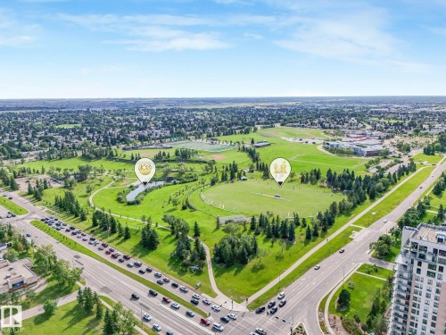 Expansive green spaces featuring walking paths, varied tree coverage, open fields, and a tranquil pond - #2 3311 58 St Nw, Edmonton, AB - Outdoor With View