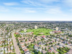 Aerial perspective showcasing a residential area with a prominent green space - 