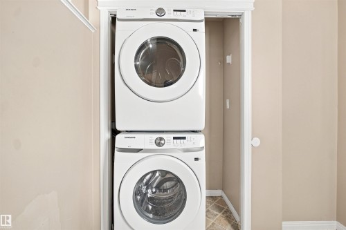 Dedicated laundry alcove featuring a stacked white front-load washer and dryer set - 1328 80 Street Sw, Edmonton, AB - Indoor Photo Showing Laundry Room