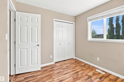 Room featuring wood-finish flooring, neutral wall tones, and white baseboards - 1328 80 Street Sw, Edmonton, AB - Indoor Photo Showing Other Room