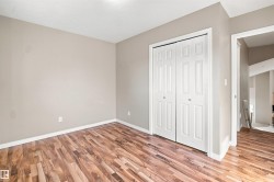 Interior space featuring wood-finish flooring, light neutral wall paint, and white bi-fold closet doors - 