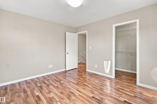 Room featuring wood-finish flooring, neutral wall tones, white trim, and a ceiling-mounted light fixture - 1328 80 Street Sw, Edmonton, AB - Indoor Photo Showing Other Room
