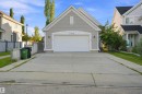 Light gray siding exterior with a white garage door featuring an arched transom - 1328 80 Street Sw, Edmonton, AB  - Outdoor 