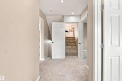 Hallway featuring light beige carpeting and recessed lighting - 