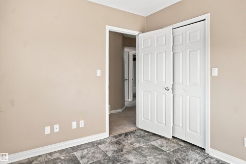 Room featuring grey patterned flooring, neutral wall tones, and white trim - 1328 80 Street Sw, Edmonton, AB - Indoor Photo Showing Other Room