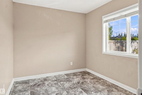 Room featuring a large window, tiled flooring, and light-toned walls - 1328 80 Street Sw, Edmonton, AB - Indoor Photo Showing Other Room