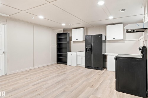 Expansive room featuring light wood-finish flooring, recessed lighting, and white paneling - 1328 80 Street Sw, Edmonton, AB - Indoor