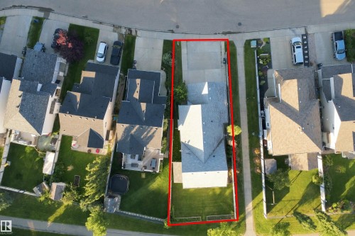 Property with a distinct roofline, extensive driveway, and a spacious green lawn - 1328 80 Street Sw, Edmonton, AB - Other