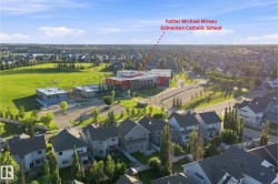 Aerial view of a residential community featuring numerous single-family homes with gray roofs and varied siding - 