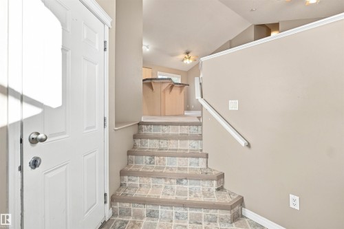 Entryway featuring tile-finish stairs and neutral wall tones - 1328 80 Street Sw, Edmonton, AB - Indoor Photo Showing Other Room