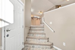 Entryway featuring tile-finish stairs and neutral wall tones - 